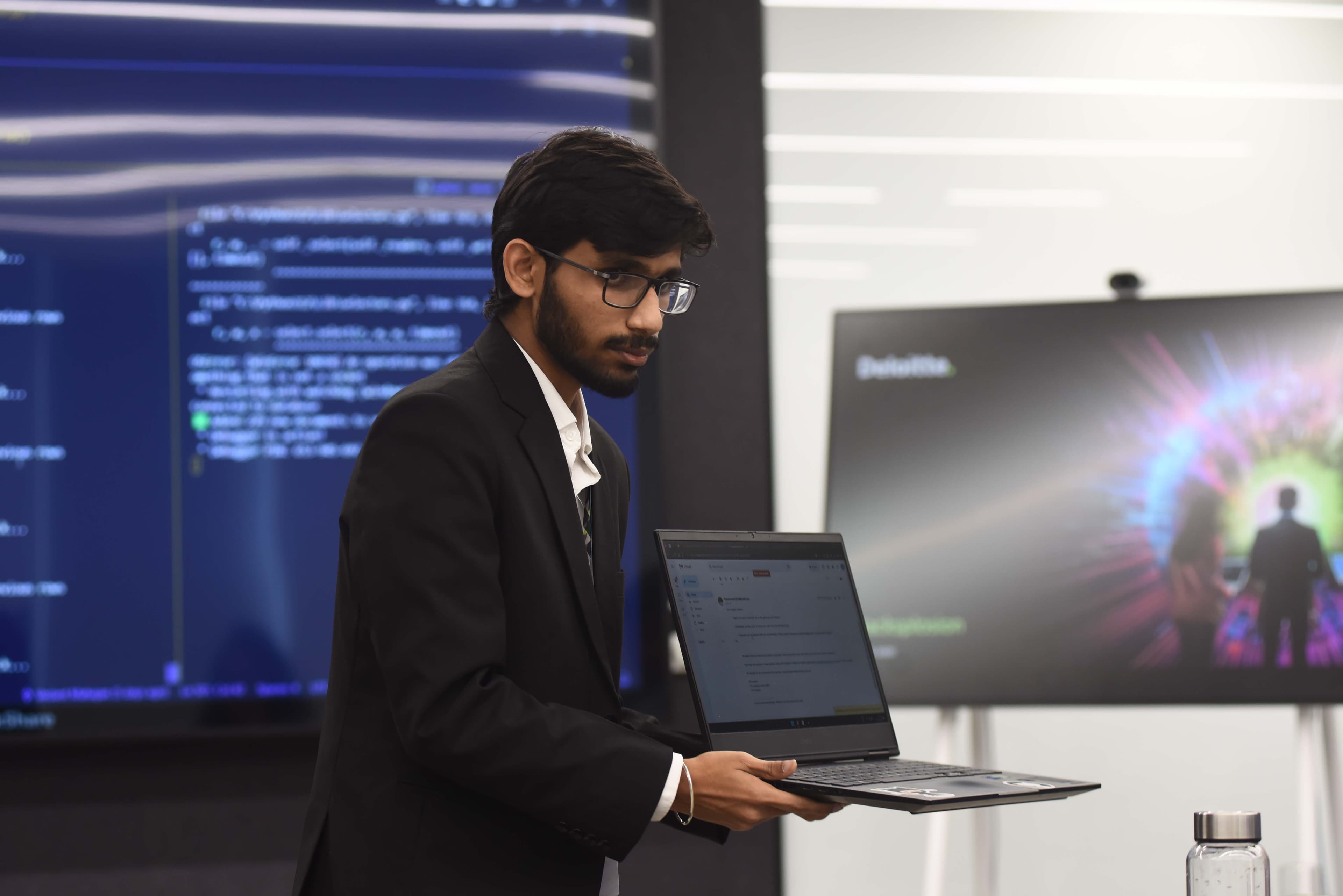 Vedant Mahajan presenting software on a laptop